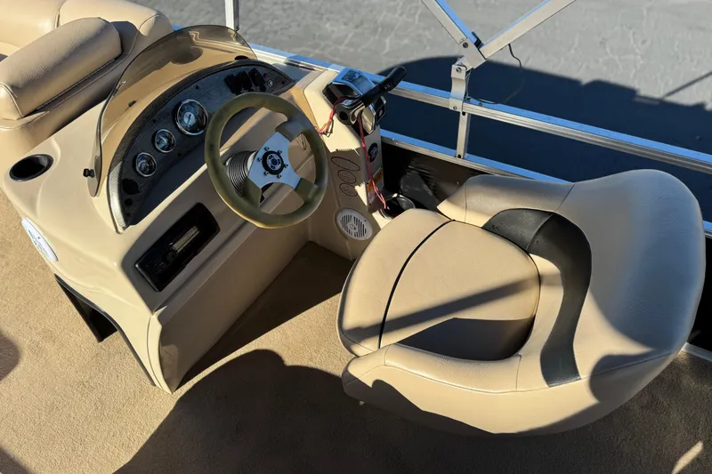 Slide: The Image of 2011 Harris Cruiser 220 CX boat interior with steering wheel and beige seating. - 21