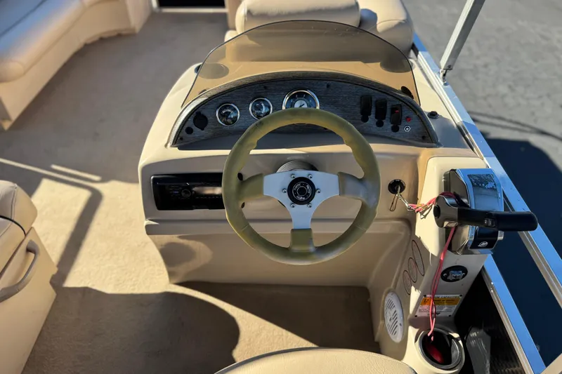 Slide: The Image of 2011 Harris Cruiser 220 CX boat dashboard with steering wheel and controls. - 22