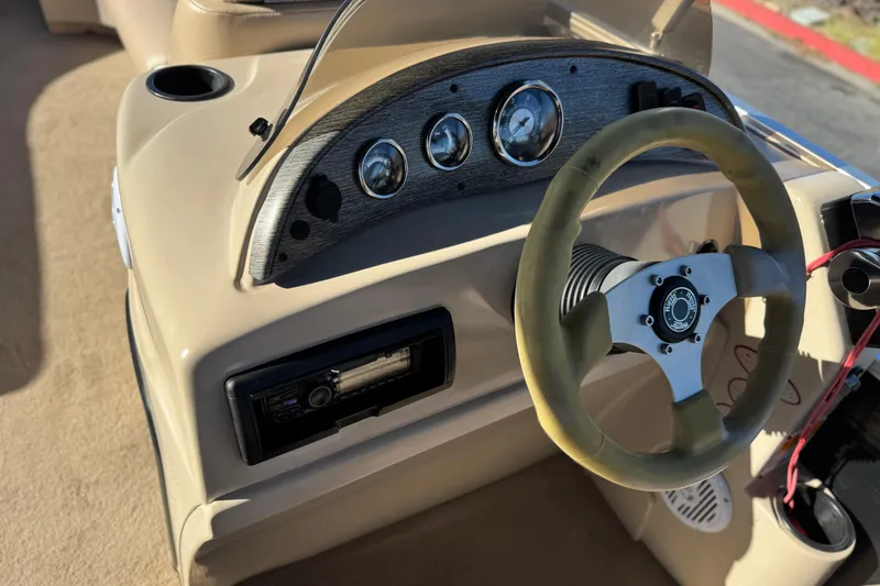 Slide: The Image of 2011 Harris Cruiser 220 CX boat dashboard with steering wheel and gauges. - 23