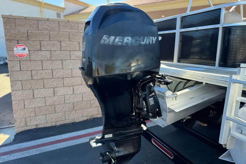 Slide: The Image of 2011 Harris Cruiser 220 CX with Mercury outboard motor, parked near a brick wall. - 7