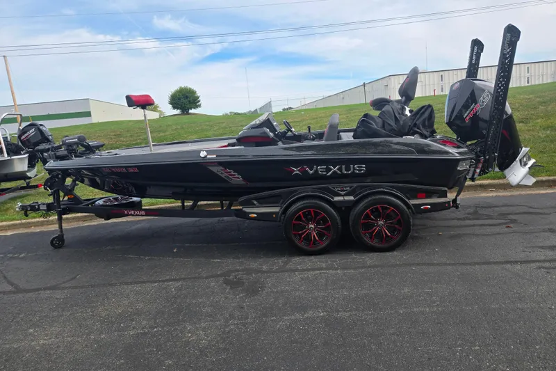 Slide: The Image of 2022 Vexus VX20 boat on trailer, black with red accents, parked outdoors. - 4