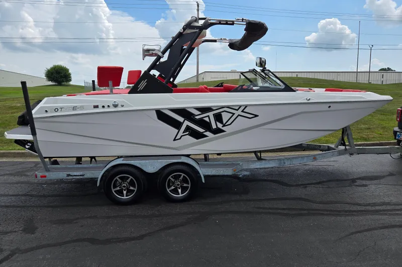 Slide: The Image of 2022 ATX Surf Boats 20 Type-S on trailer, white with red interior, parked outdoors. - 4
