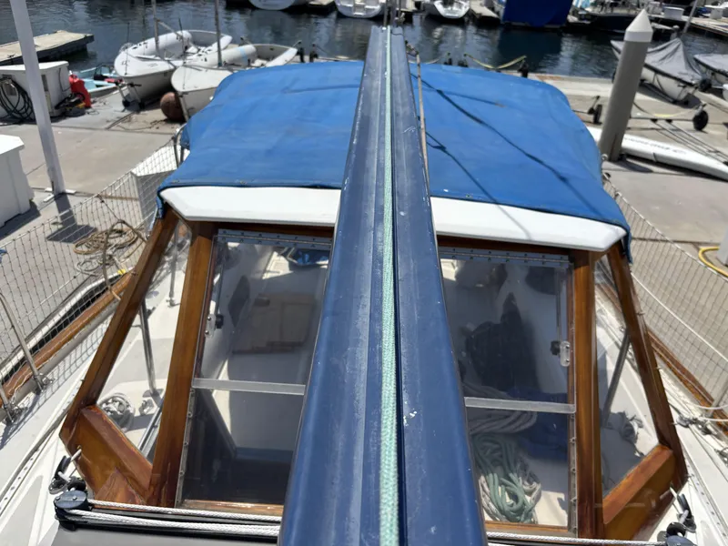 Slide: The Image of 1982 Norseman 447 sailboat with blue cover docked at marina. - 10