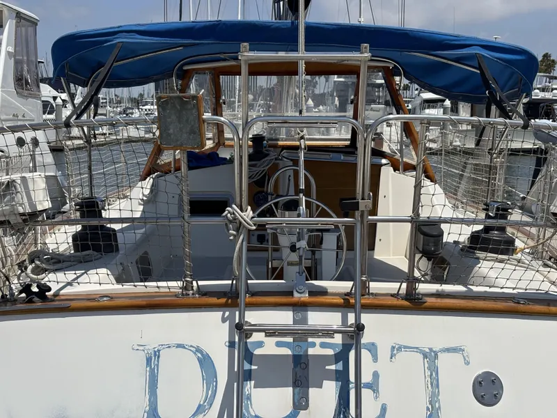 Slide: The Image of Sailboat Norseman 447, 1982 model, docked with blue canopy and visible steering wheel. - 15