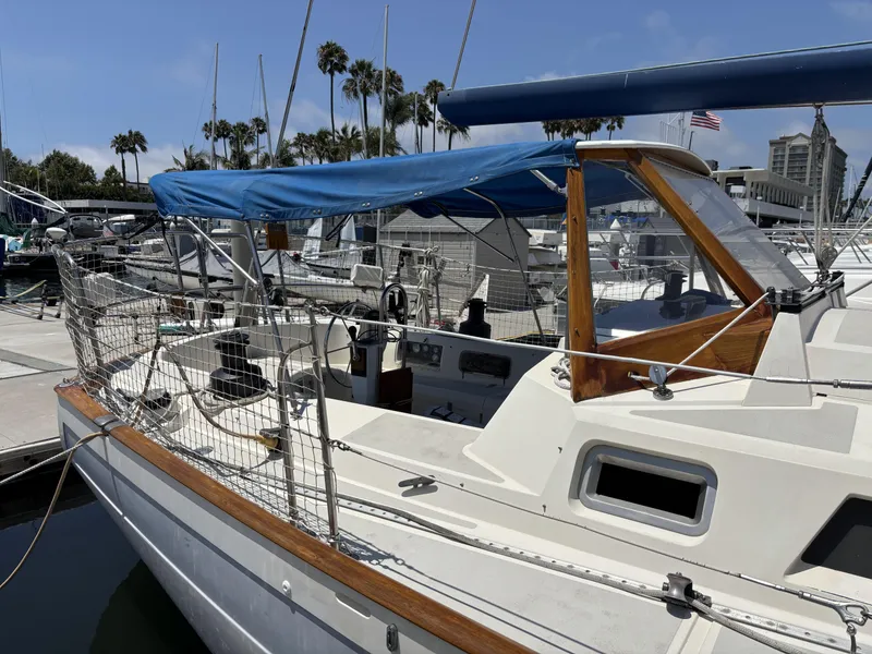 Slide: The Image of Sailboat docked at marina, Norseman 447, 1982 model, with blue canopy and wooden accents. - 16