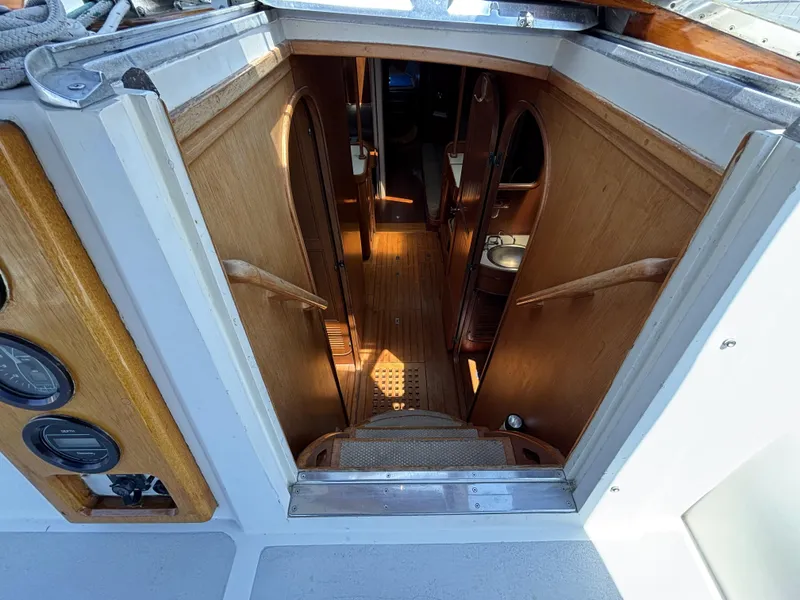Slide: The Image of Interior view of 1982 Norseman 447 yacht, featuring wooden stairs and cabin entry. - 29