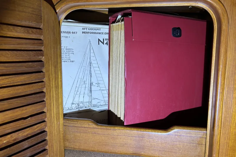 Slide: The Image of Red folder and Norseman 447 sailboat plans inside wooden cabinet. - 34