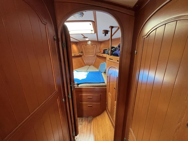 Slide: The Image of Cozy wooden cabin interior of 1982 Norseman 447 sailboat, featuring a bed and storage. - 39