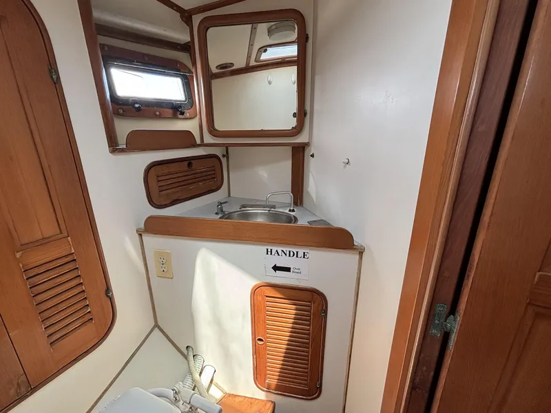 Slide: The Image of Compact bathroom in 1982 Norseman 447 boat with wooden accents and small sink. - 42