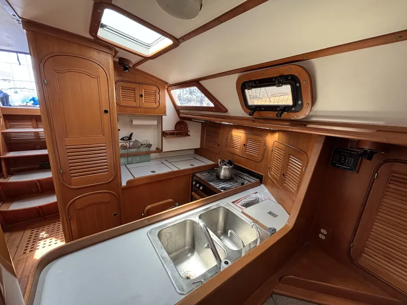 Slide: The Image of Interior of 1982 Norseman 447 sailboat kitchen with wooden cabinetry and stainless steel sink. - 46