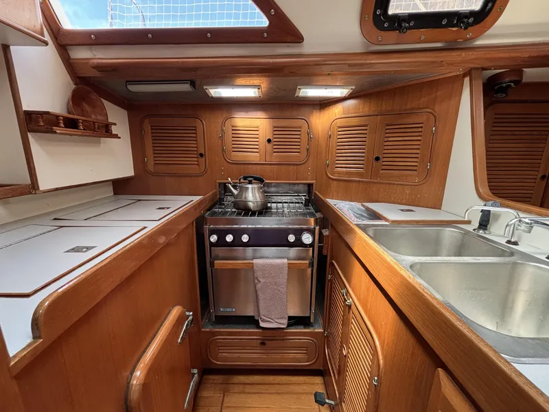 Slide: The Image of 1982 Norseman 447 yacht kitchen with wooden cabinets, stove, and stainless steel sink. - 47