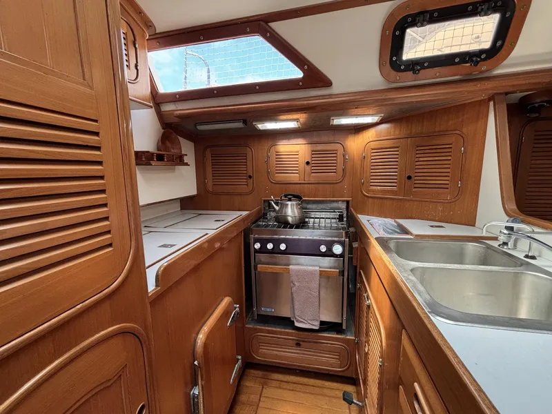 Slide: The Image of 1982 Norseman 447 yacht kitchen with wooden cabinetry, stove, and sink. - 48