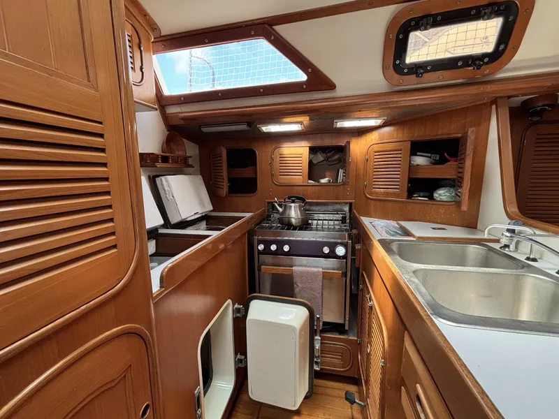 Slide: The Image of 1982 Norseman 447 yacht kitchen with wooden cabinetry, stove, and sink. - 49
