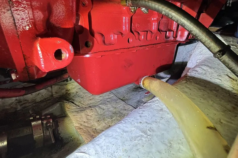 Slide: The Image of Red engine component of 1982 Norseman 447 with attached hoses in a mechanical setting. - 68