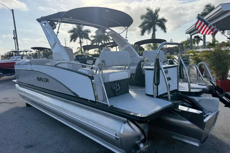 Slide: The Image of 2026 Avalon 2385 Catalina Quad Lounger Tri Toon boat, sleek design, docked under palm trees. - 13