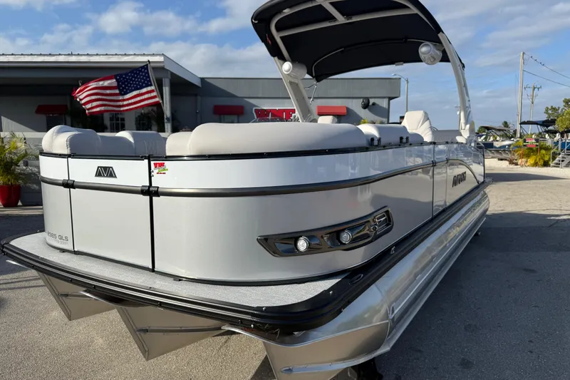 Slide: The Image of 2026 Avalon 2385 Catalina Quad Lounger Tri Toon boat, silver exterior, docked with American flag. - 4