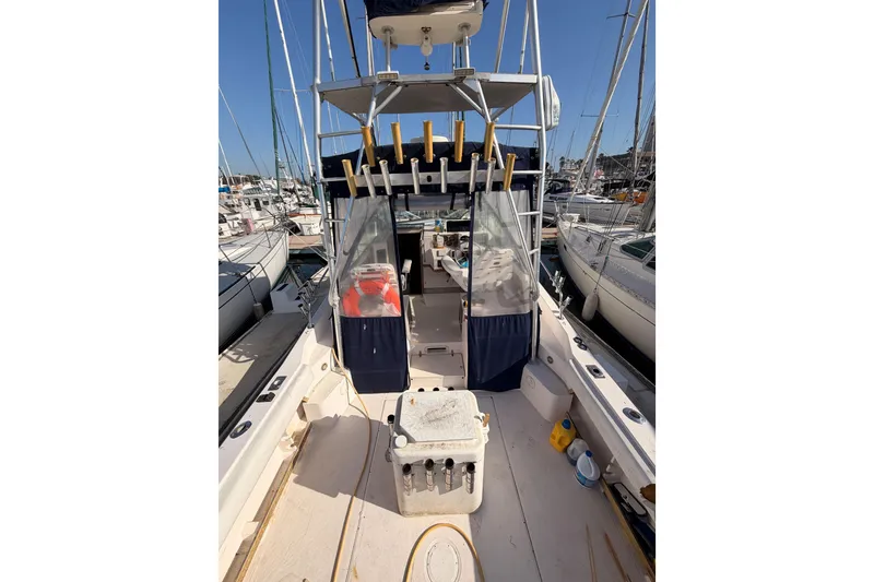 Slide: The Image of 1993 Grady-White Marlin 300 boat docked in a marina, featuring fishing rod holders. - 10
