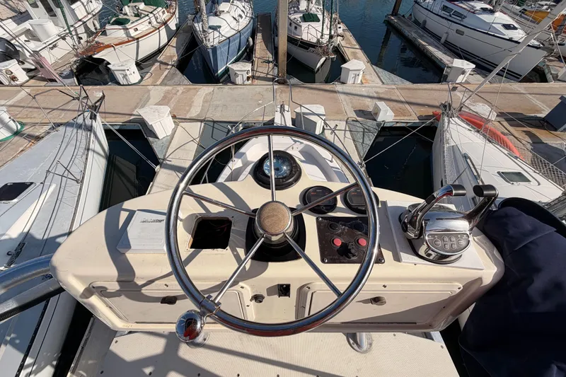 Slide: The Image of 1993 Grady-White Marlin 300 boat helm with steering wheel and controls, docked at marina. - 11