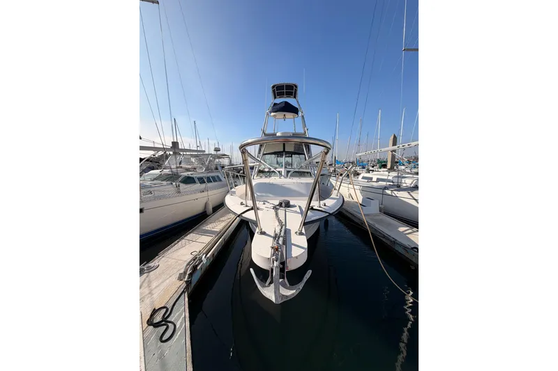 Slide: The Image of 1993 Grady-White Marlin 300 boat docked at marina, clear sky background. - 2