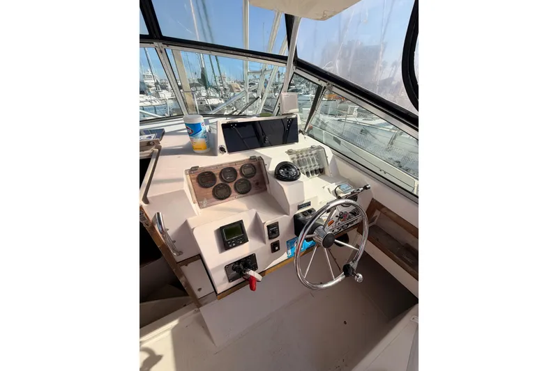 Slide: The Image of 1993 Grady-White Marlin 300 boat helm with steering wheel and instrument panel. - 23
