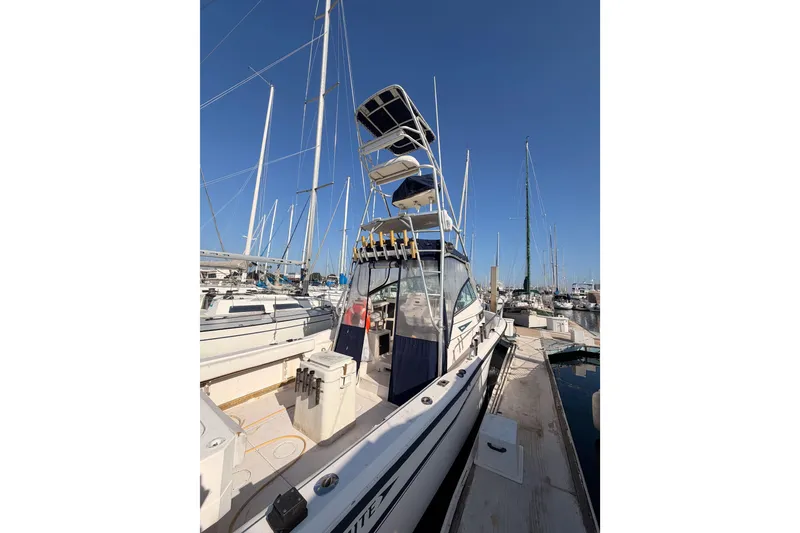 Slide: The Image of 1993 Grady-White Marlin 300 boat docked at marina, clear blue sky background. - 6