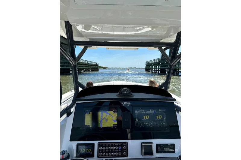 Slide: The Image of 2021 Sea Fox 288 Commander dashboard view, navigating through a waterway. - 2