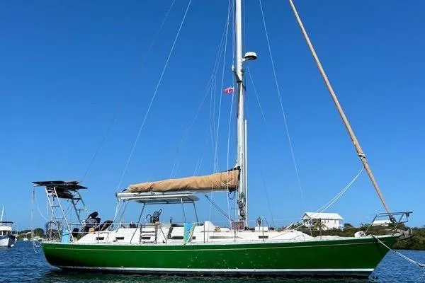 The Image of 1989 Hylas 44 sailboat with green hull on stands, clear blue sky background. - 0