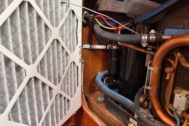 Slide: The Image of Engine compartment of a 1989 Hylas 44 sailboat with visible air filter and wiring. - 101