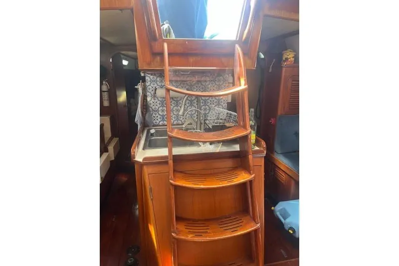 Slide: The Image of Hylas 44 sailboat from 1989 on stands in a boatyard under a blue sky. - 11