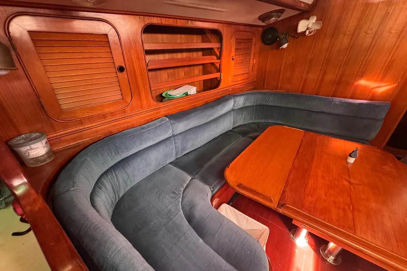 Slide: The Image of Cozy interior of 1989 Hylas 44 sailboat with blue cushioned seating and wooden table. - 113