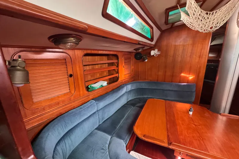 Slide: The Image of Cozy interior of 1989 Hylas 44 yacht with wooden paneling and blue seating. - 115