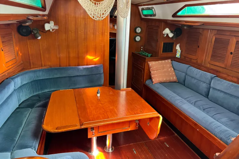 Slide: The Image of Interior of 1989 Hylas 44 yacht with wooden table and blue seating. - 117