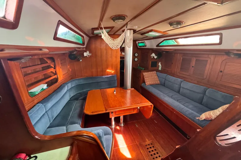 Slide: The Image of Cozy interior of 1989 Hylas 44 yacht with blue seating and wooden table. - 118