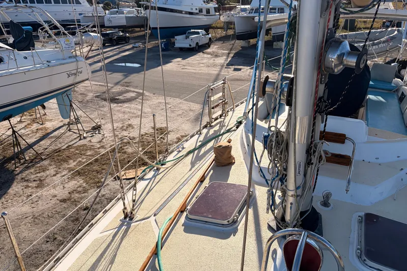 Slide: The Image of 1989 Hylas 44 sailboat on dry dock, surrounded by other boats and equipment. - 119