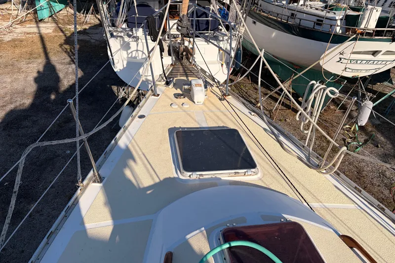 Slide: The Image of 1989 Hylas 44 sailboat deck with rigging and hatch, docked alongside other boats. - 121