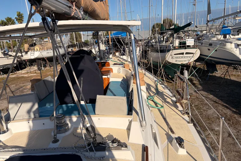 Slide: The Image of 1989 Hylas 44 sailboat on dry dock, surrounded by other boats, under clear blue sky. - 124