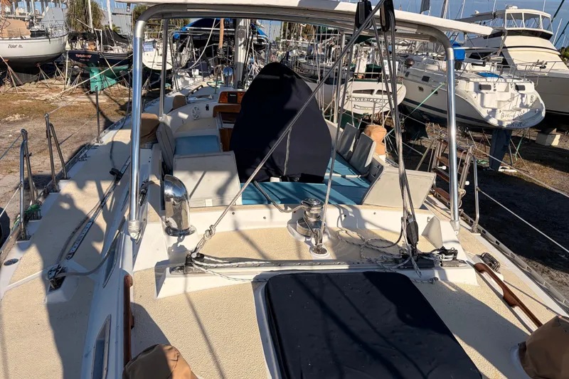 Slide: The Image of 1989 Hylas 44 sailboat deck with winches and seating, docked in a marina. - 125