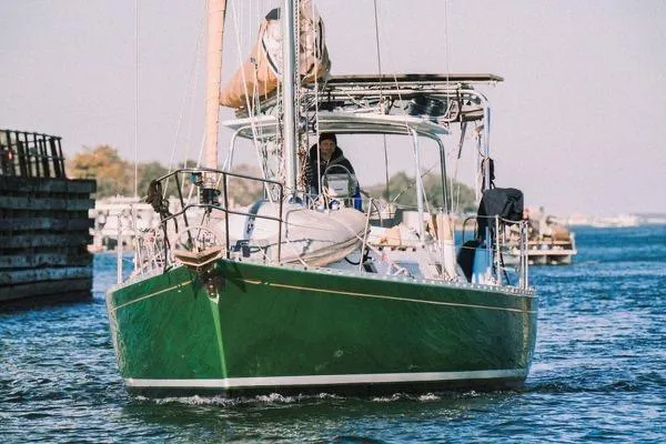 Slide: The Image of Green 1989 Hylas 44 sailboat on stands, under clear blue sky. - 2