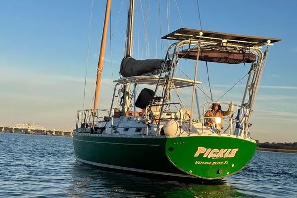 Slide: The Image of 1989 Hylas 44 sailboat named "Pickle" on calm water at sunset. - 21