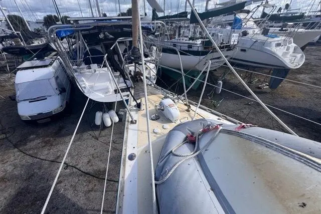 Slide: The Image of Sailboat Hylas 44 (1989) in dry dock, surrounded by other boats and a van. - 25