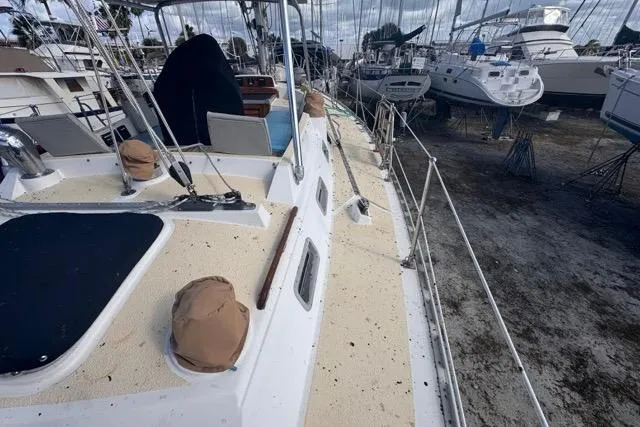 Slide: The Image of 1989 Hylas 44 sailboat on dry dock, surrounded by other vessels. - 28