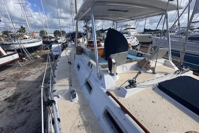 Slide: The Image of 1989 Hylas 44 sailboat on deck, surrounded by other boats in a marina. - 29