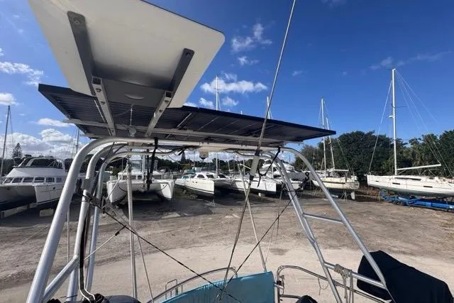 Slide: The Image of Sailboat with solar panel, Hylas 44, 1989 model, docked in a marina under clear blue sky. - 32