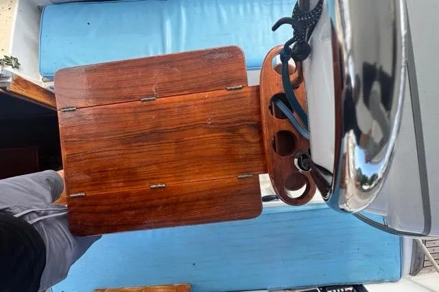 Slide: The Image of Wooden table on a 1989 Hylas 44 yacht with blue seating and steering wheel. - 42