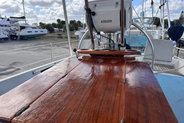 Slide: The Image of Polished wooden deck of 1989 Hylas 44 sailboat with marina background. - 51