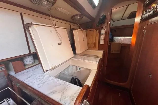 Slide: The Image of Interior of 1989 Hylas 44 yacht with open storage compartments and wooden finishes. - 54