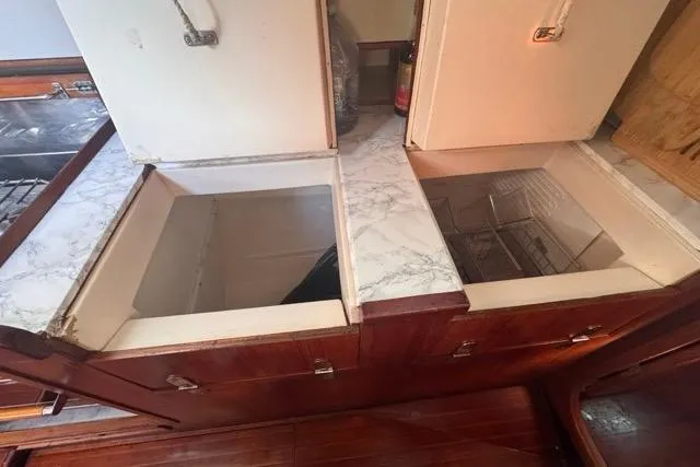 Slide: The Image of Interior of 1989 Hylas 44 yacht showing open storage compartments in the galley. - 56