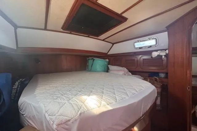 Slide: The Image of Cozy cabin interior of 1989 Hylas 44 sailboat with bed and wooden paneling. - 57