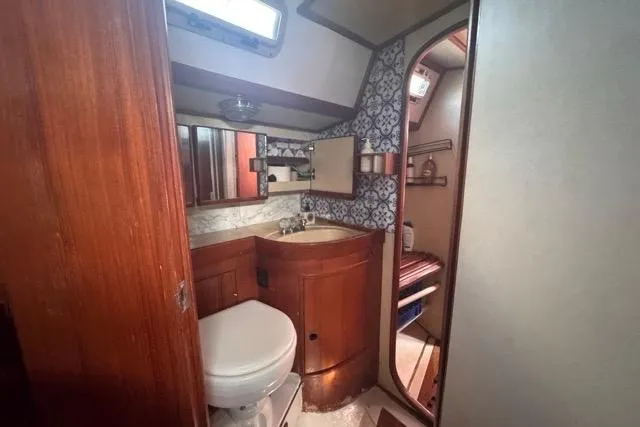 Slide: The Image of Interior of 1989 Hylas 44 yacht bathroom with wooden cabinetry and patterned wall. - 58