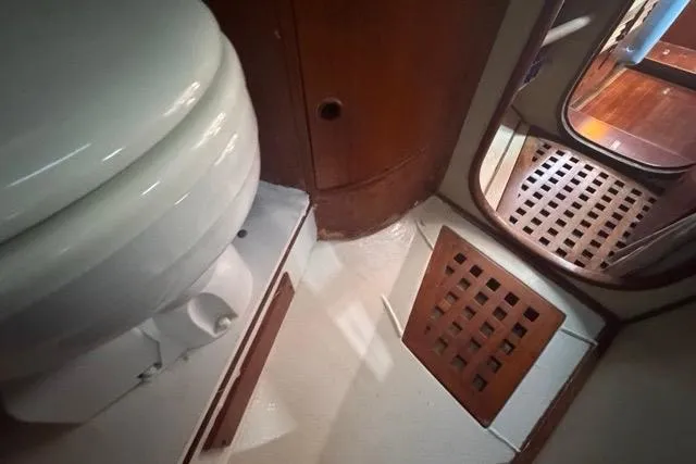 Slide: The Image of Interior of 1989 Hylas 44 yacht bathroom with wooden accents and toilet. - 61